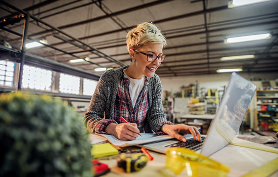 A woman banking from her laptop while in her small business